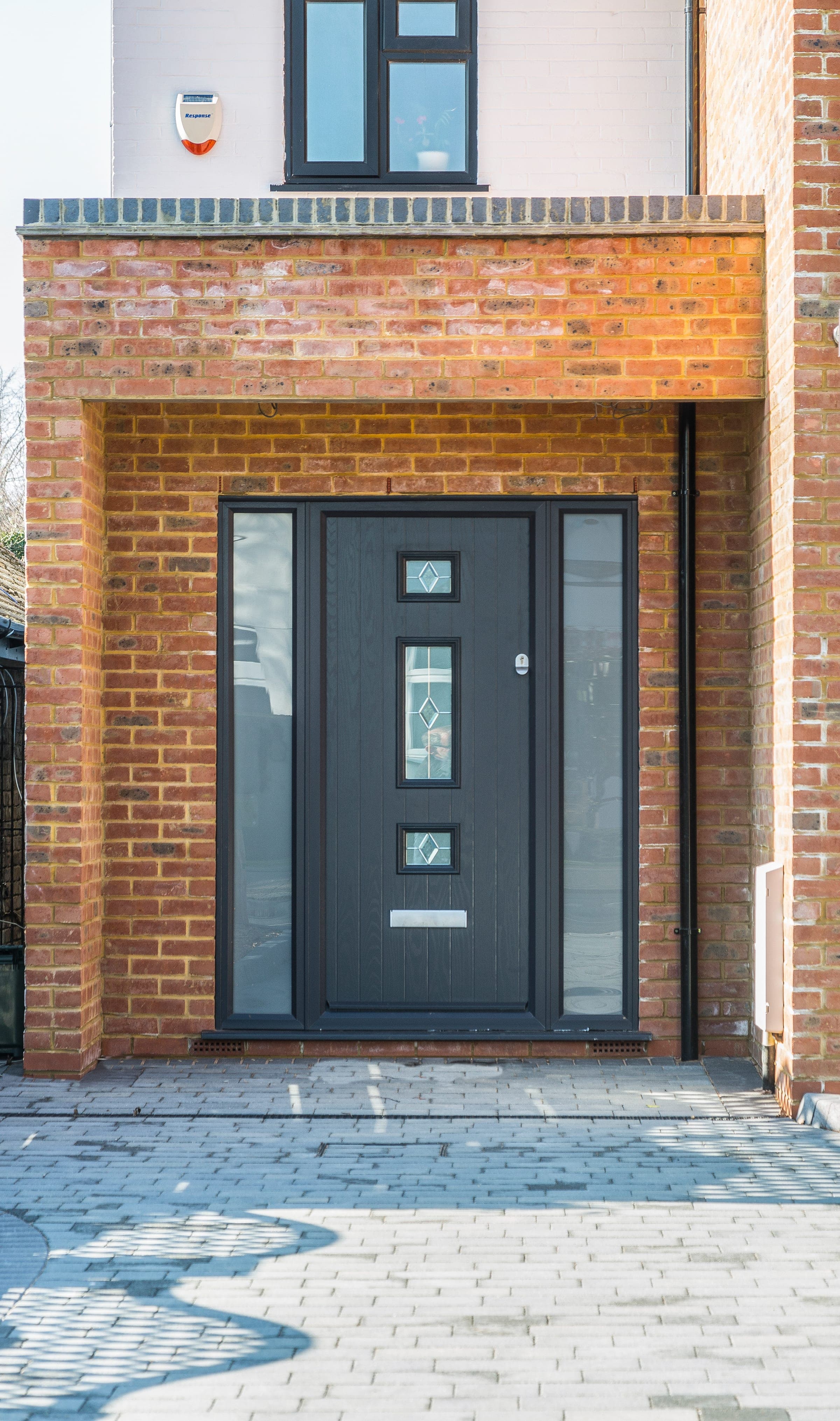 Anthracite composite front door, brick surround