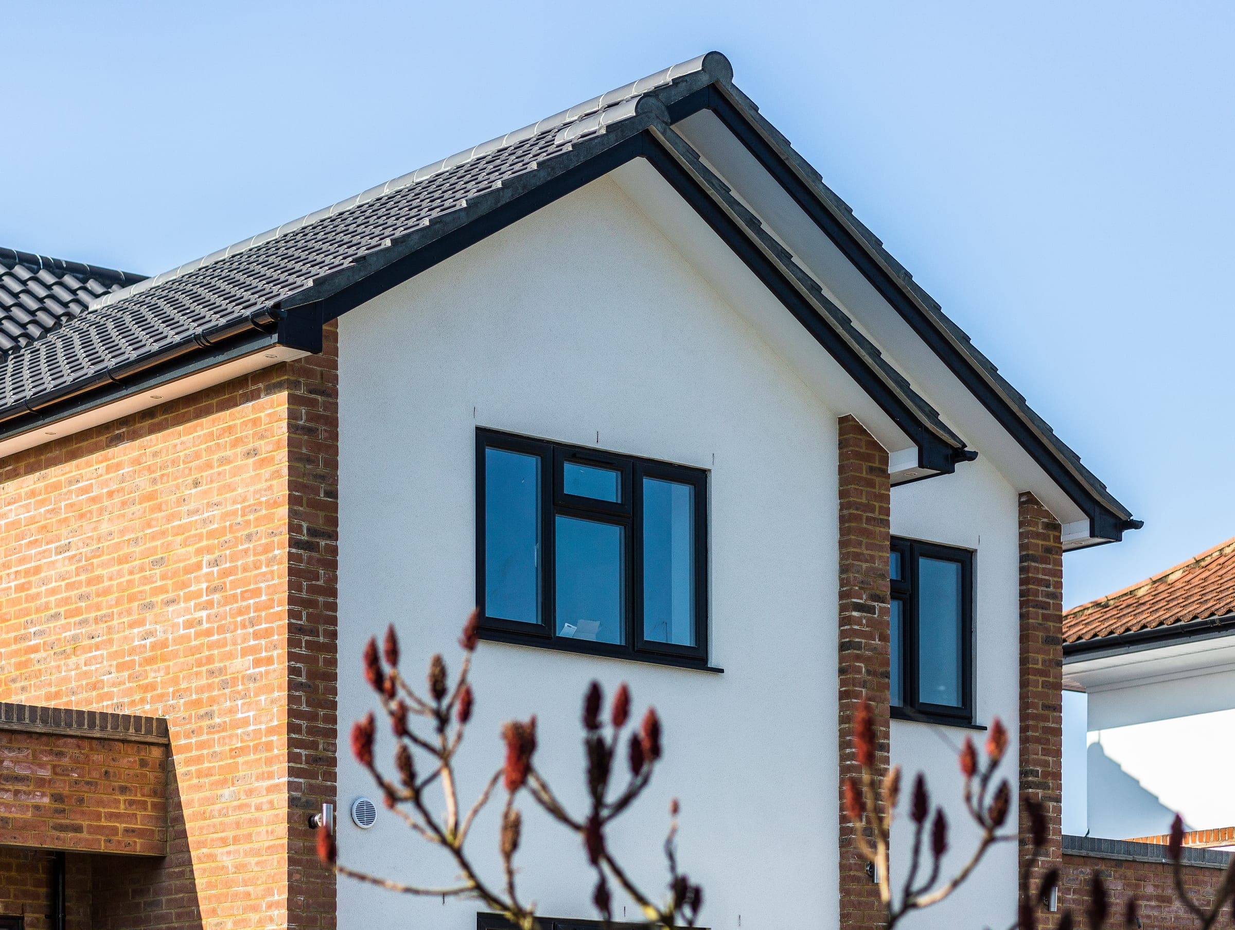 Gable end, clay tile roof and rendered apex